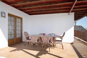a dining room with a table and chairs on a patio at Villa Jeamir I in Playa Blanca