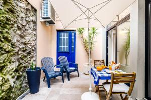 a patio with a table and chairs and a blue door at Ladomar Avenida in Horta