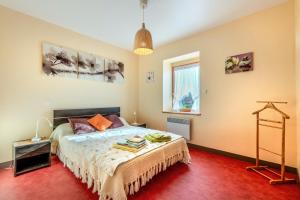 a bedroom with a bed and a red carpet at Maison de caractère à Roscoff in Roscoff