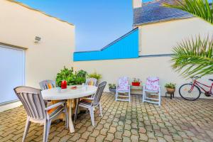 a patio with a table and chairs and a bike at Maison de caractère à Roscoff in Roscoff