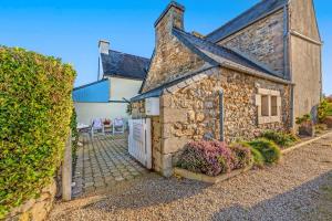 a stone house with a gate and a fence at Maison de caractère à Roscoff in Roscoff