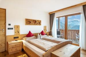 a bedroom with a bed and a large window at Hatzes App Schlern in Laion