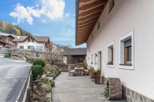 a patio with a table and chairs next to a house at Hatzes App Schlern in Laion