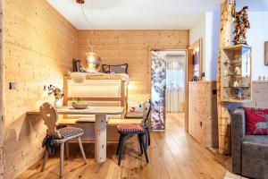 a dining room with wooden walls and a table and chairs at Hatzes App Schlern in Laion