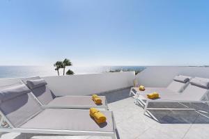 a balcony with two lounge chairs and the ocean at Bungalow Seaview in San Bartolomé
