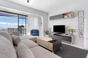 a living room with a couch and a tv at Bungalow Seaview in San Bartolomé