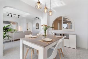 a white dining room with a white table and chairs at Bungalow Seaview in San Bartolomé
