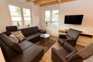 a living room with two couches and a tv at Ferienwohnung Stratmann in Lennestadt