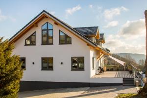 a white house with a gambrel roof at Ferienwohnung Stratmann in Lennestadt