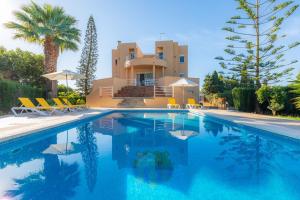 a villa with a swimming pool in front of a house at Ca Na Xisca in Sa Coma