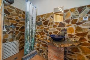 a stone bathroom with a sink and a shower at Horta Do Zé Miguel in Monchique