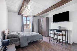 a bedroom with a bed and a desk with a television at Chambres d'hôtes Le Plessis in Frossay