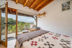 a bedroom with a bed and a balcony at Horta Do Zé Miguel in Monchique