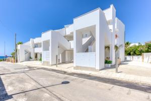 a white building on the side of a road at Residence Fronte Mare in Ugento