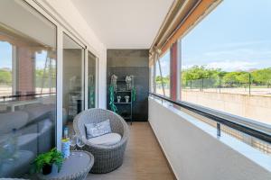 a balcony with two chairs and a table and windows at Boliche in Benimagrell