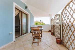 a room with a table and chairs on a balcony at Casa Perla in Villasimius