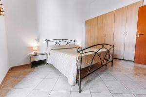 a bedroom with a bed and a wooden cabinet at Casa Perla in Villasimius
