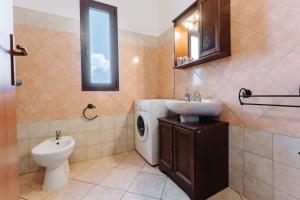 a bathroom with a toilet a sink and a washing machine at Casa Perla in Villasimius +21 photos