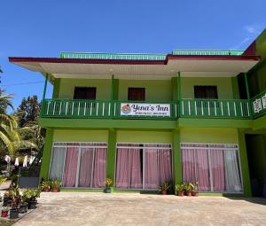 a green building with a sign on it at Yena's Inn in Cauayan