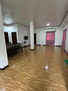 a large room with a wooden floor and tables and chairs at Yena's Inn in Cauayan