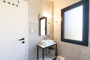 a bathroom with a sink and a mirror at Eirini's Apartment in Kanoni +20 photos