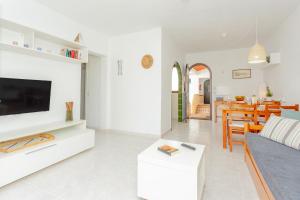 a living room with a couch and a tv at Los Delfines Biniforcat in Ciutadella