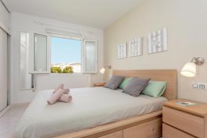 a bedroom with a bed with a teddy bear on it at Los Delfines Biniforcat in Ciutadella