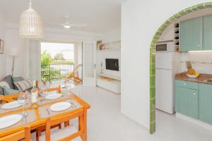 a kitchen and living room with a table and chairs at Los Delfines Biniforcat in Ciutadella
