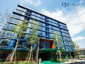 a tall building with trees in front of it at 130 Hotel & Residence Bangkok in Bangkok