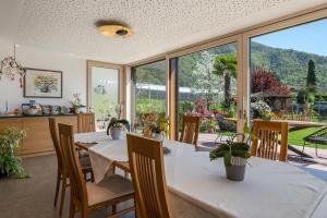a dining room with a table and chairs and a large window at Haus Rosengarten Apt A in Terlano