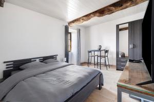 a bedroom with a large bed and a table at Chambres d'hôtes Le Plessis in Frossay