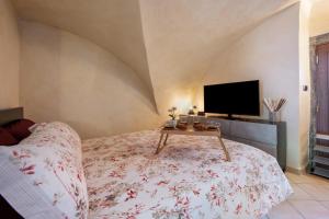 a bedroom with a bed with a tv and a table at Le Volte - Lago D'Iseo in Pisogne