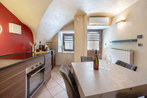a kitchen with a table with wine glasses on it at Le Volte - Lago D'Iseo in Pisogne