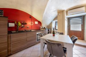 a kitchen with red walls and a table and chairs at Le Volte - Lago D'Iseo in Pisogne +18 photos