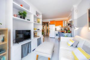 a living room with a white couch and a tv at Formentorgloria in Port de Pollensa +16 photos