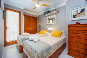 a bedroom with two beds and a dresser at Formentorgloria in Port de Pollensa