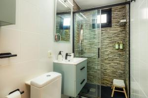 a bathroom with a toilet and a sink and a shower at Formentorgloria in Port de Pollensa