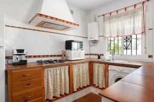 a kitchen with a stove and a microwave at Casa Paqui 1 in Roche