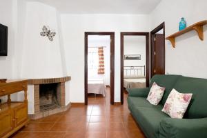 a living room with a green couch and a fireplace at Casa Paqui 1 in Roche