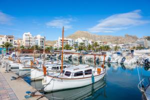 a group of boats docked in a marina with buildings at Formentorgloria in Port de Pollensa