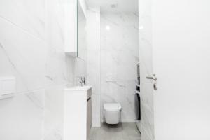 a white bathroom with a toilet and a sink at Portimao riverview T2 luxe 1 floor in Portimão +16 photos