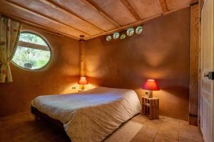 a bedroom with a bed and a window and two lamps at Gîte Écologique - Le Nid des Anges in Saint-André-Lachamp