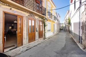 an empty street in an alley with buildings at Casa Amarela in Tavira