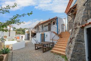 a building with stairs and a table in a courtyard at Horta Do Zé Miguel in Monchique
