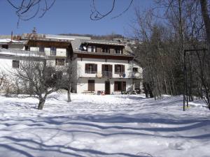 a large white house in the snow with trees at Appartement la Cascade in Allos +3 photos