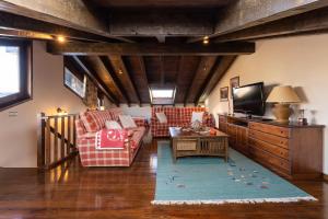 a living room with two couches and a tv at Casa Fontanals de Cerdanya in Soriguerola