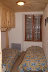 a bedroom with two beds and a window at Appartement la Cascade in Allos