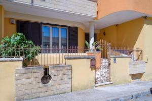 a yellow house with a fence and a window at Casa Angel in Galatone
