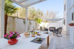 a patio with a table and chairs and flowers at Casa Angel in Galatone