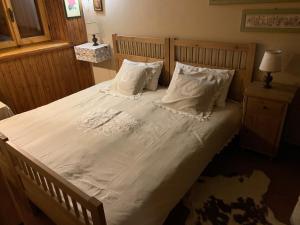 a bedroom with a large bed with white sheets and pillows at Baita Le Pozze in Abetone